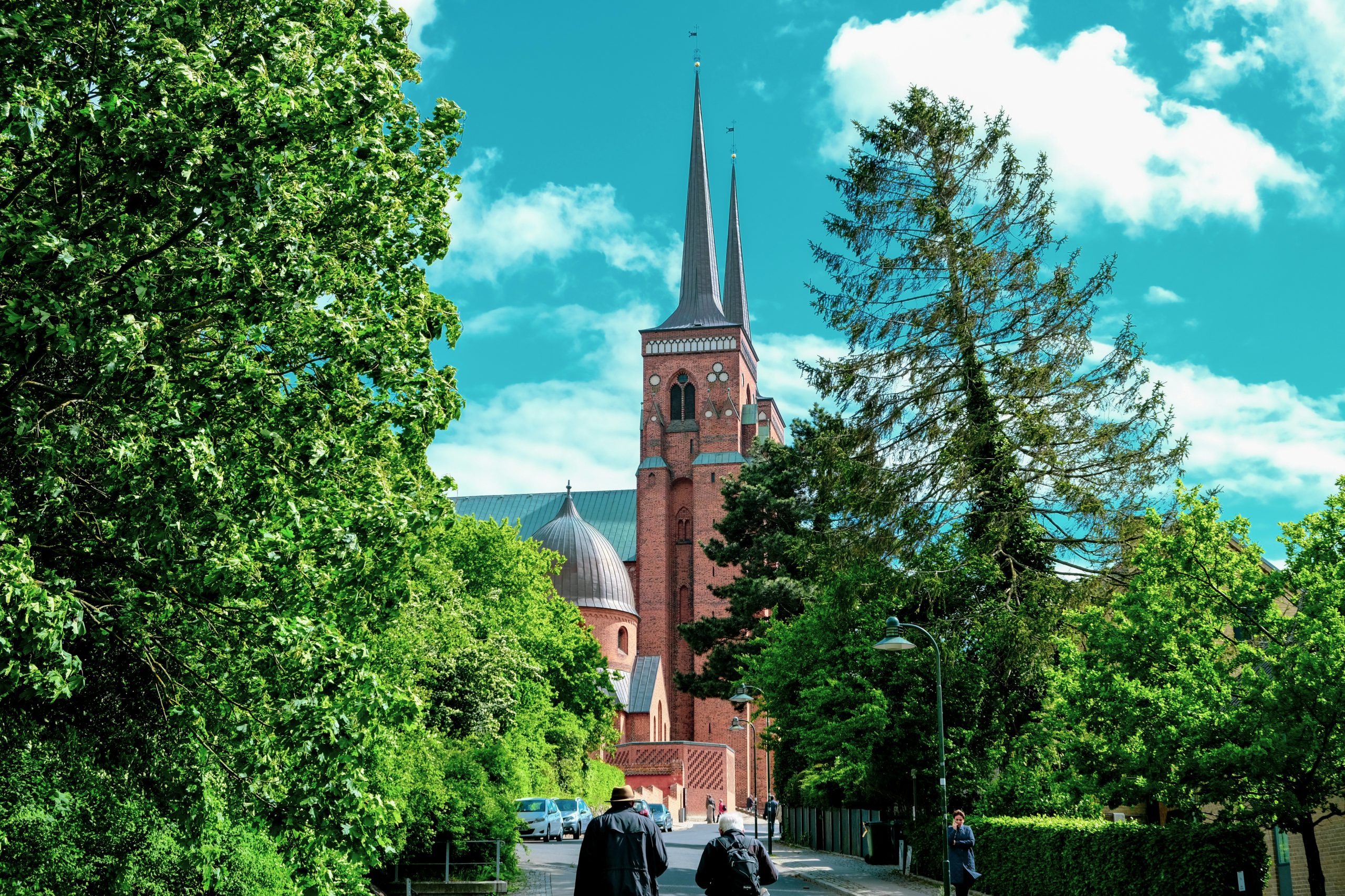 Upplyst domkyrka med torn mot natthimlen, foto som passar till quiz om Roskilde domkyrka.