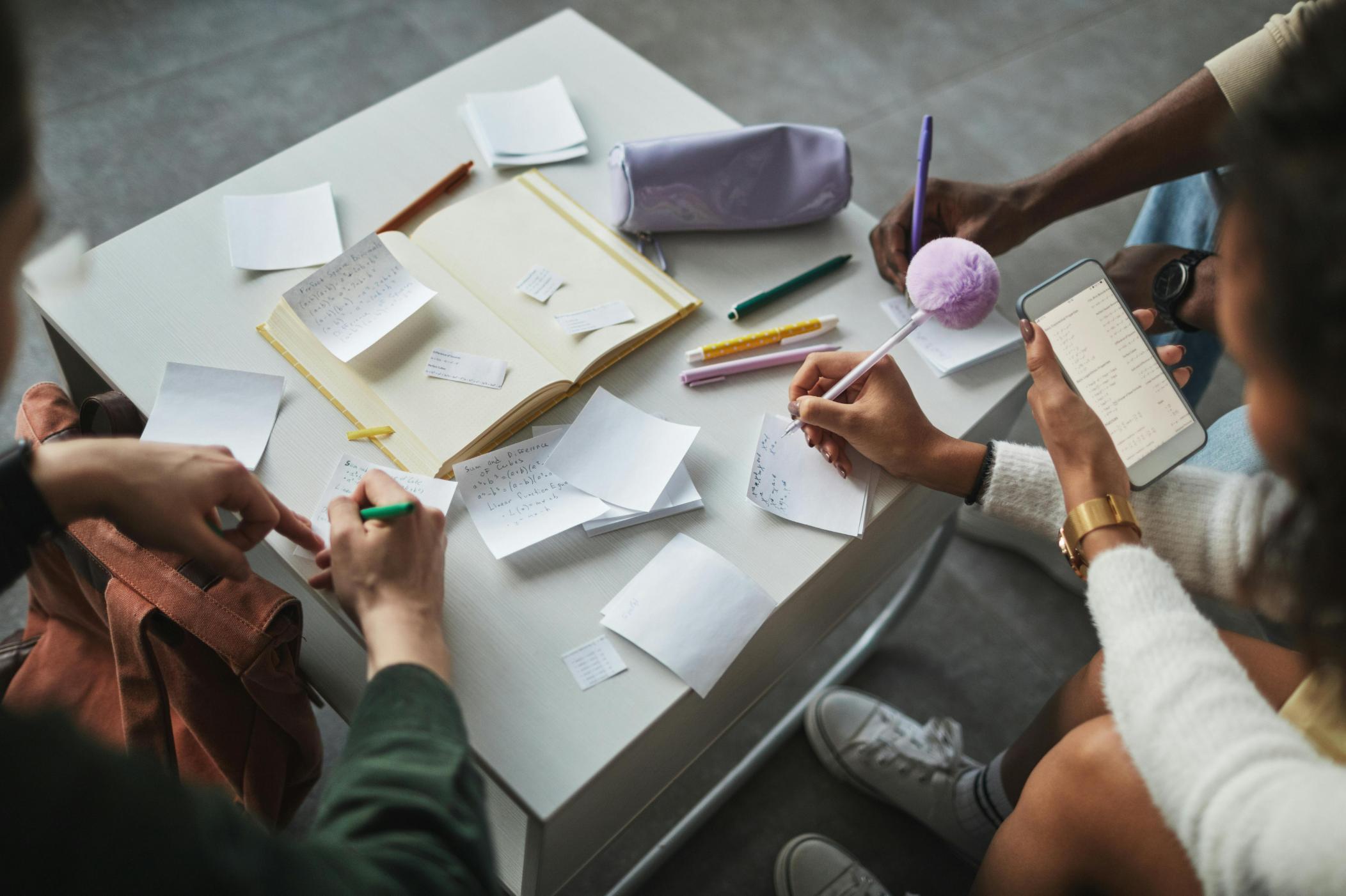 Personer runt ett bord skriver anteckningar och jämför svar i ett känsloquiz
